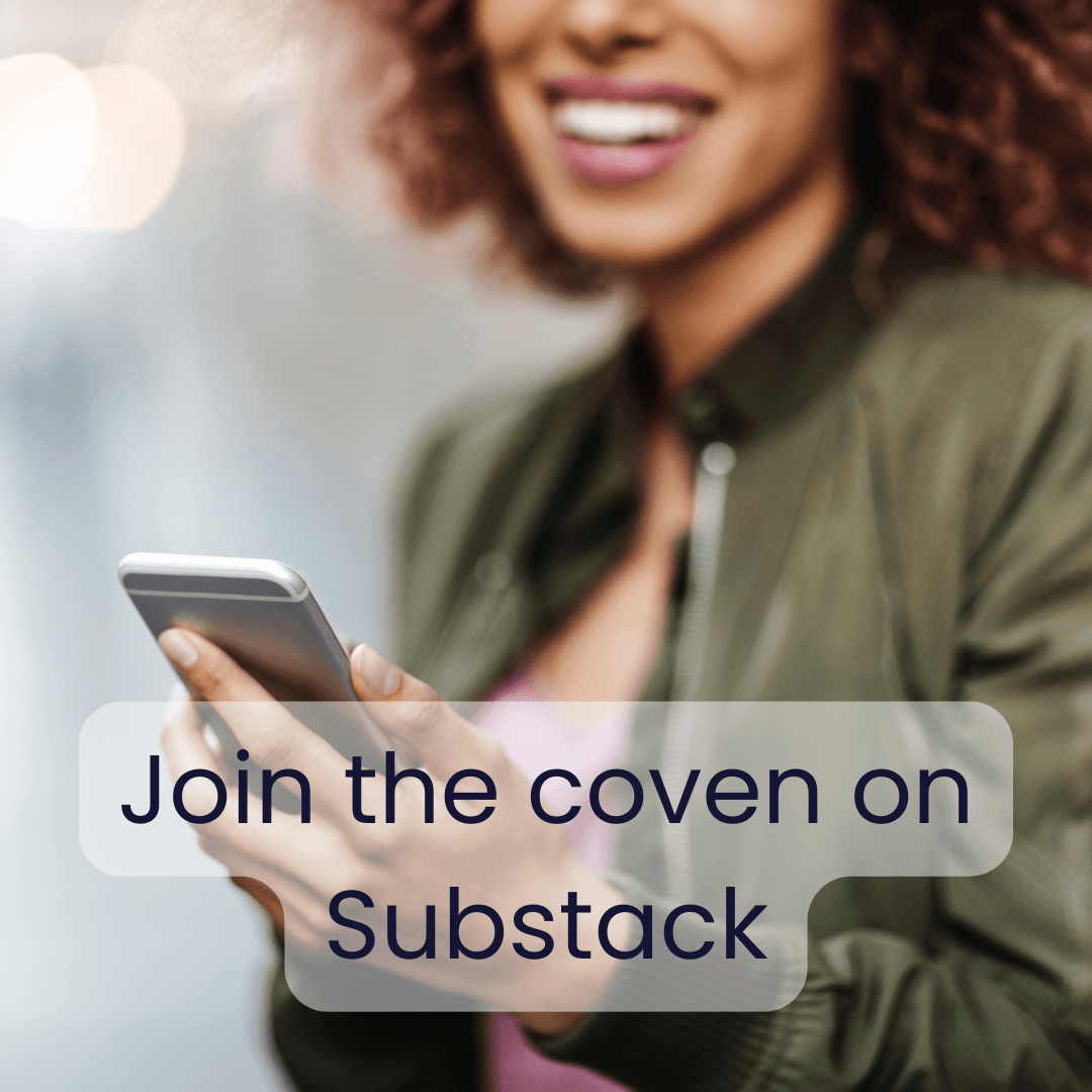 Brown woman looking at a phone in her hand and smiling.