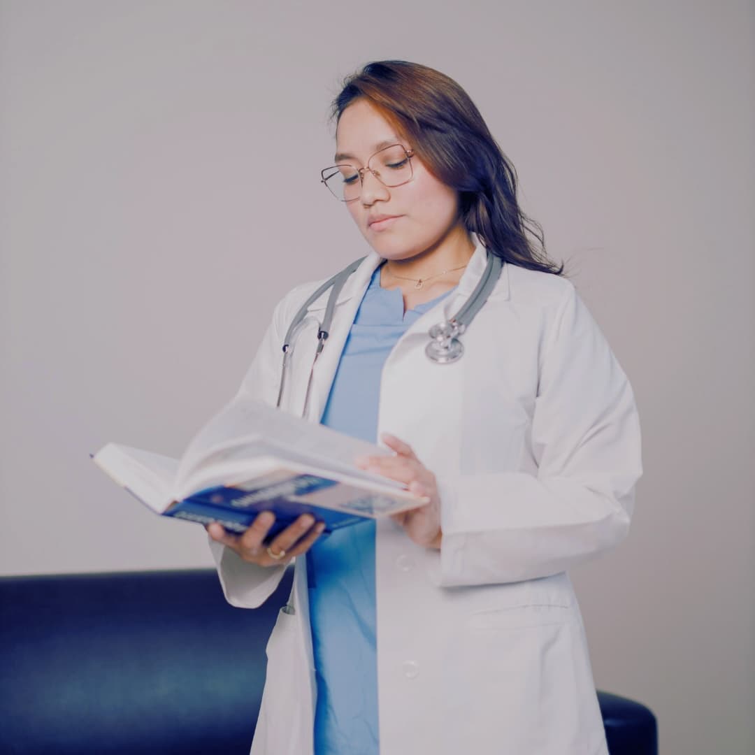 Doctor with stethoscope reading, representing the science-based foundation of menstrual cycle coaching.